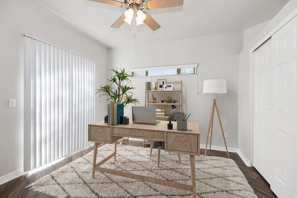 an office room with a desk and a ceiling fan