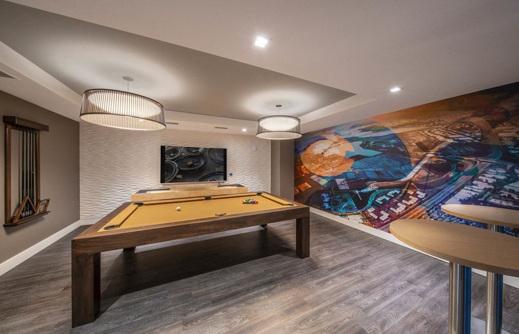 a game room with a pool table and a mural on the wall
