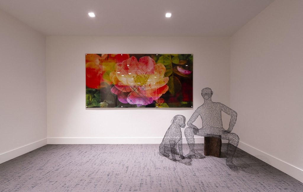 a sculpture of a man and a dog in a room with a painting of flowers