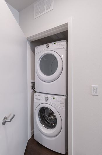 a washer and dryer in a small closet in a room with a door
