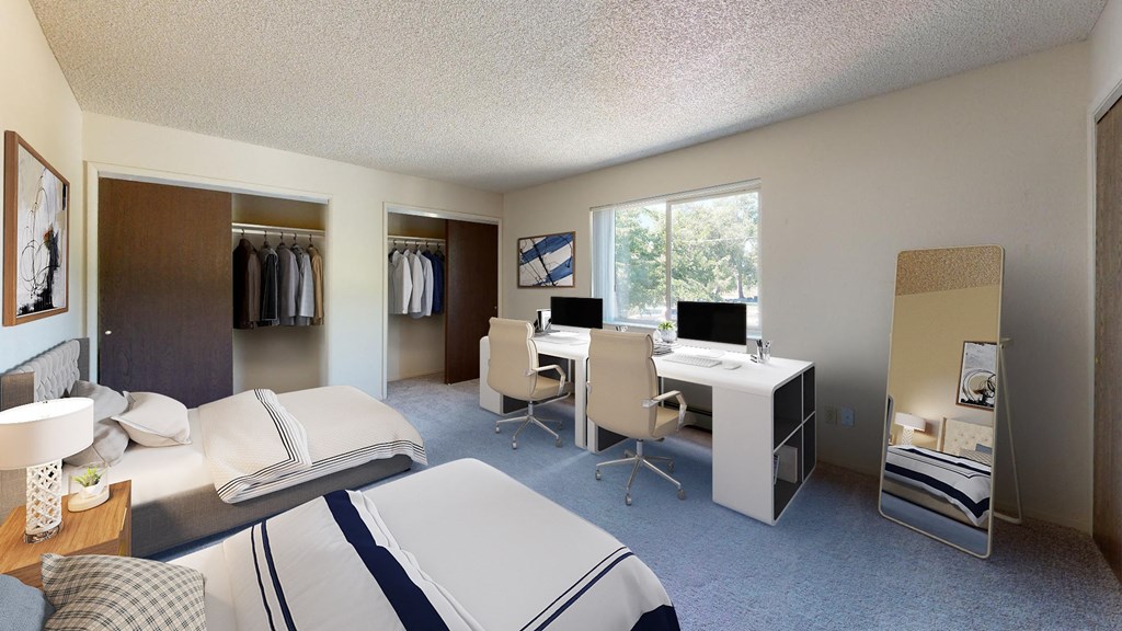 a bedroom with two beds and a desk with a computer