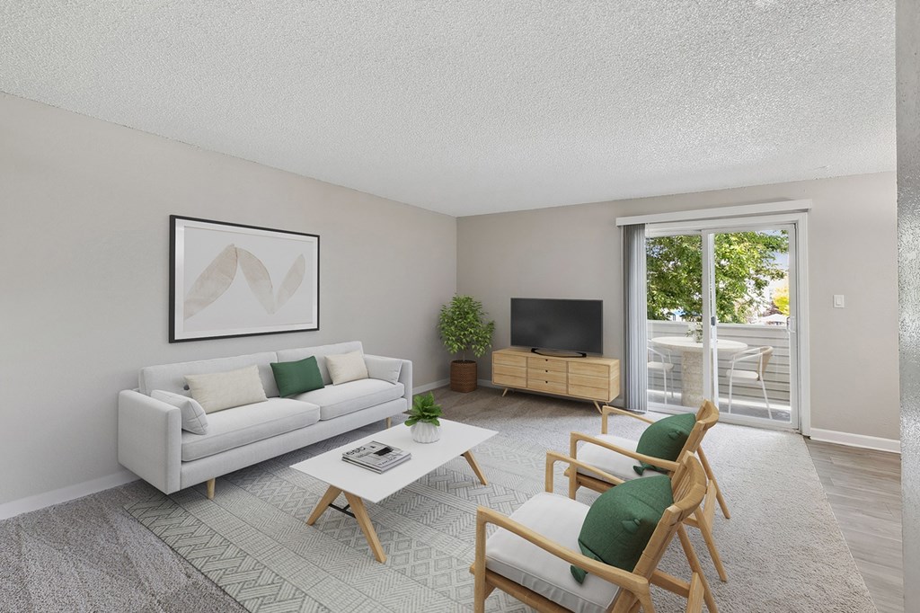 the living room of an apartment with a white couch and chairs