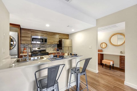 a kitchen with a bar and a counter top with two stools