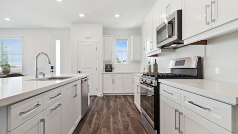 a large kitchen with white cabinets and stainless steel appliances