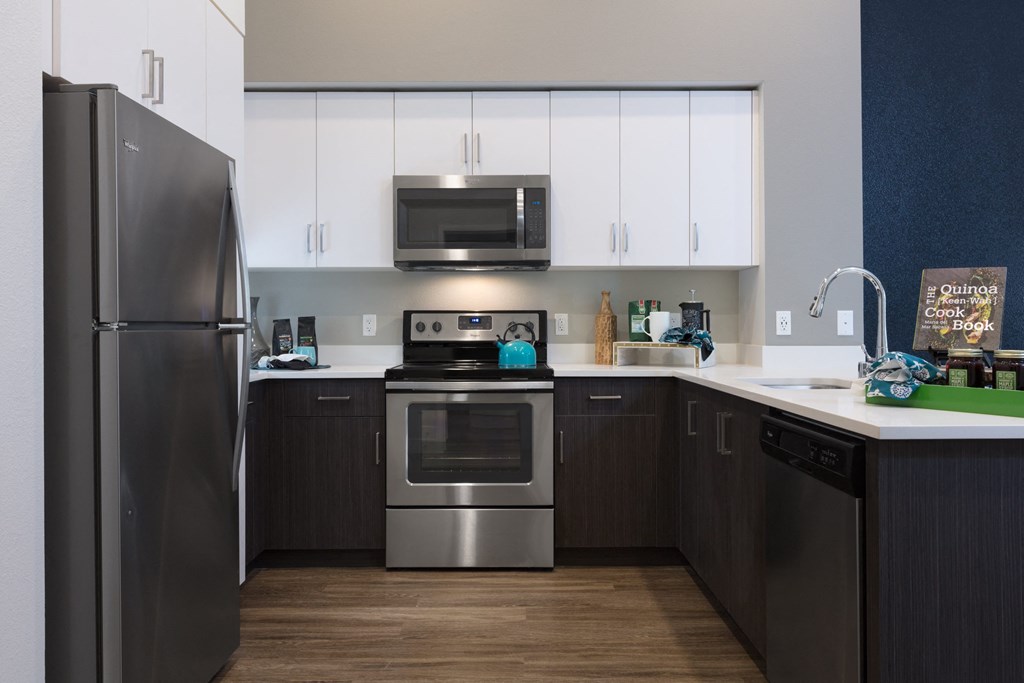 a kitchen with white cabinets and stainless steel appliances