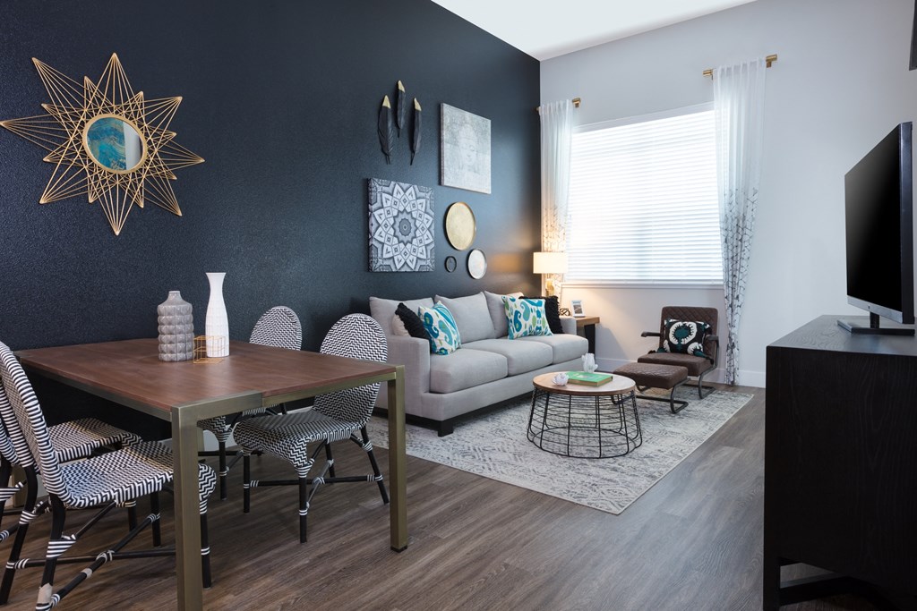 a living and dining room area with a couch table and chairs and a tv on a stand