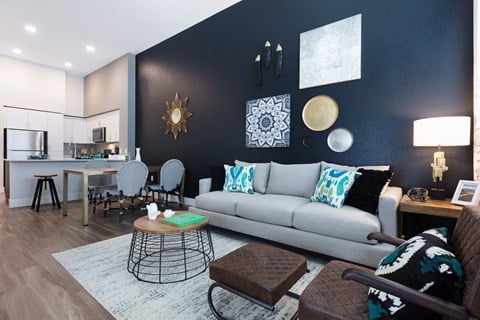 a living room with a gray couch and a black accent wall