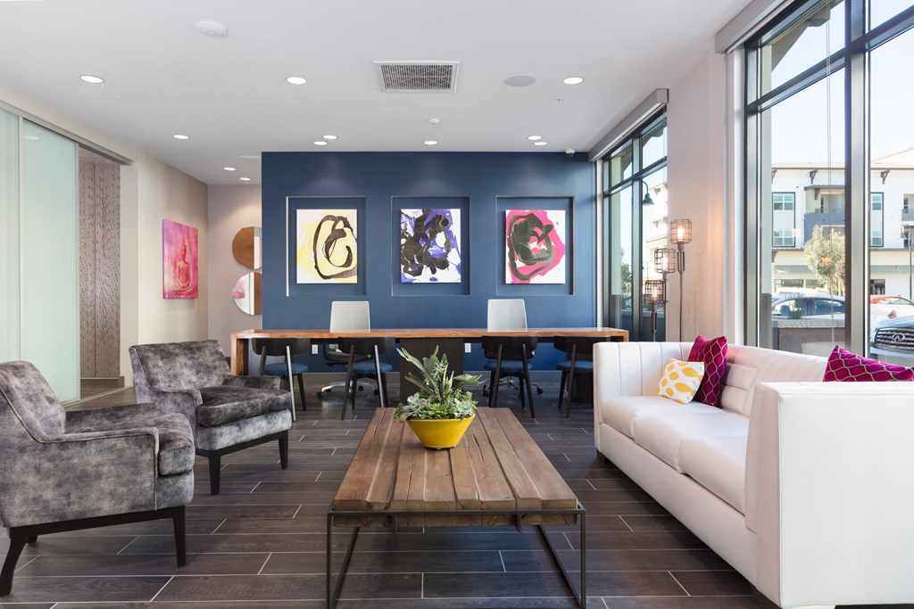 a living room with a blue accent wall and a wooden coffee table with a potted plant