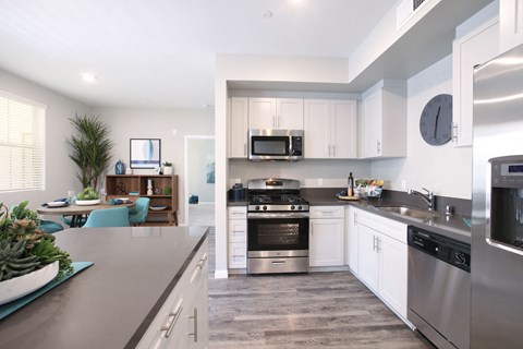 a modern kitchen with stainless steel appliances and white cabinets