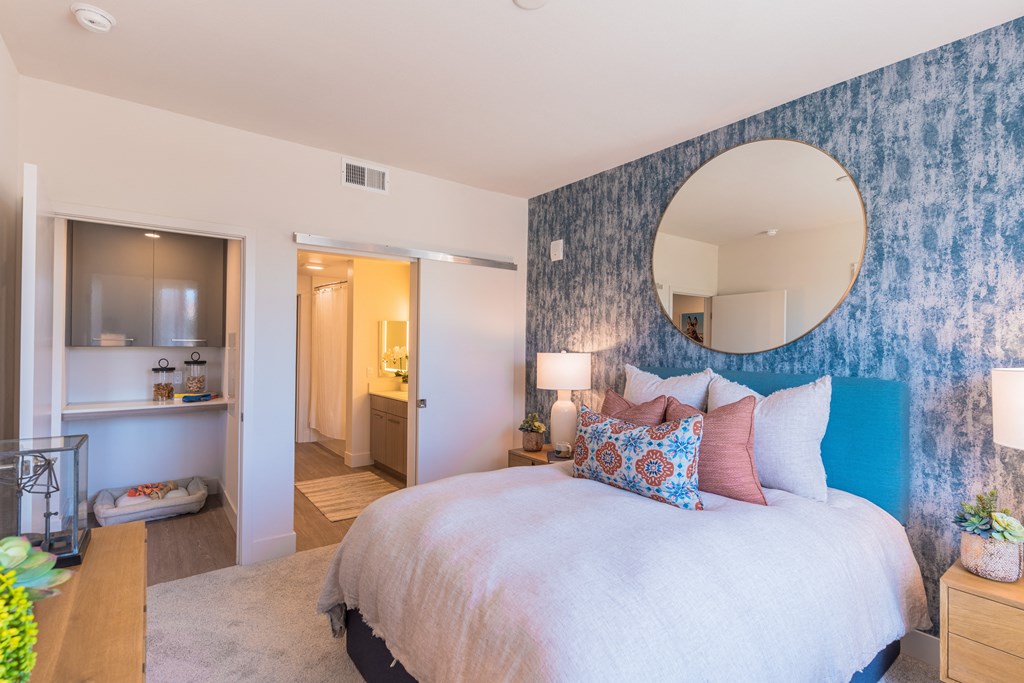 a bedroom with a large bed and a mirror on the wall