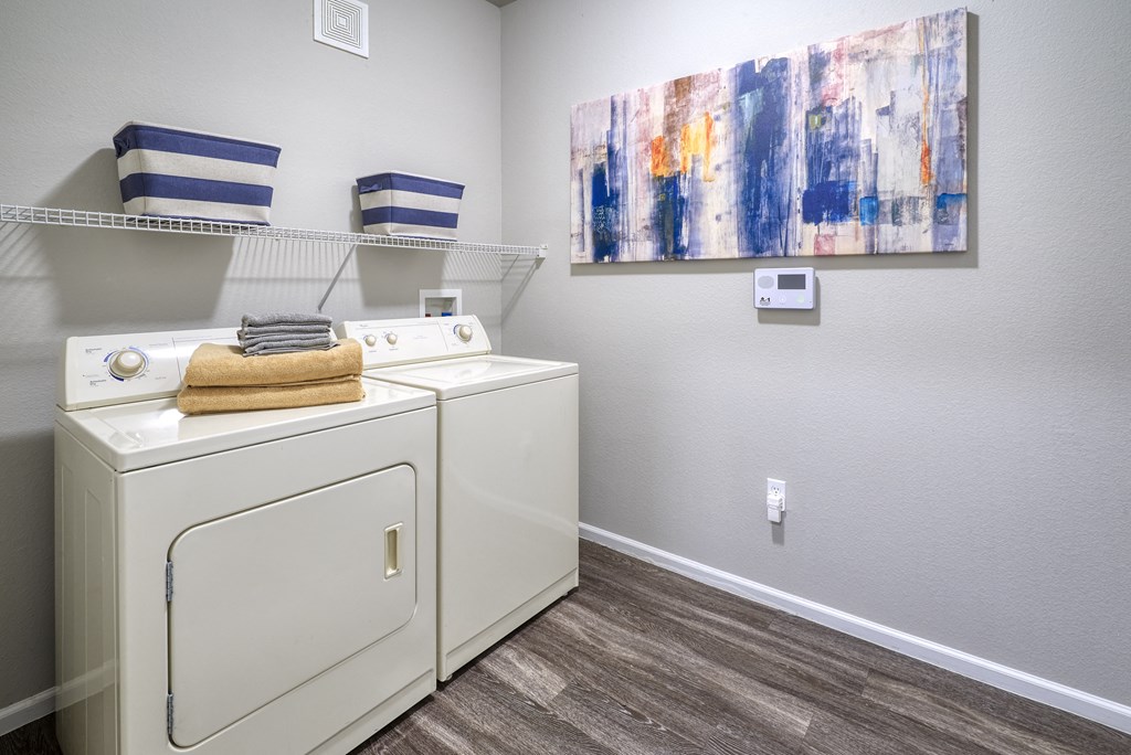 a washer and dryer in a laundry room with a painting on the wall