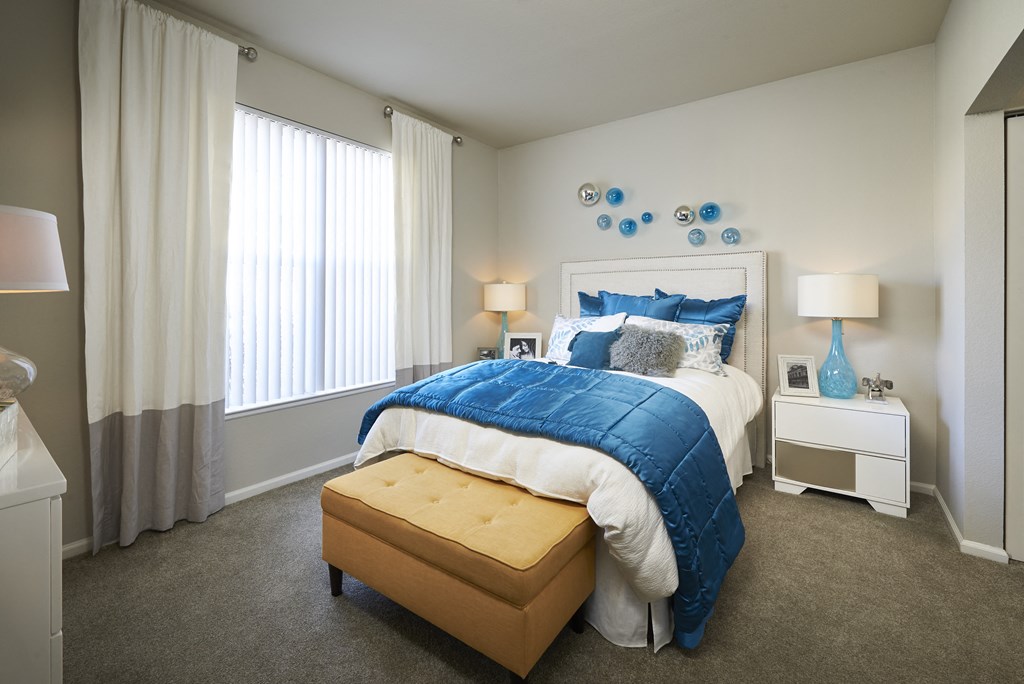 a bedroom with a large bed and blue and white bedding