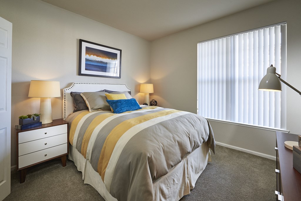 a bedroom with a bed and two windows