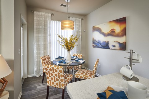 a dining room with a table and chairs and a painting on the wall