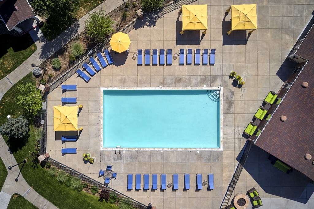 arial view of a swimming pool with blue and yellow umbrellas around it