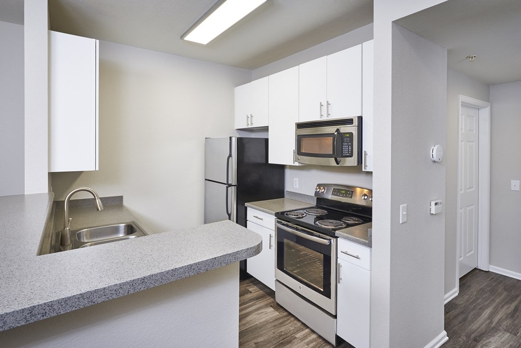 a kitchen with stainless steel appliances and white cabinets