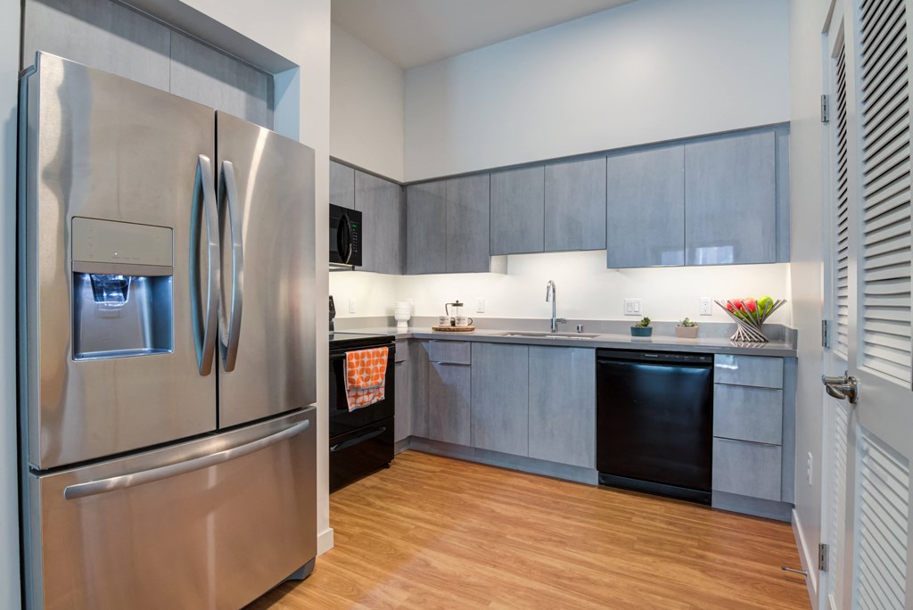 a kitchen with stainless steel appliances and a wooden floor