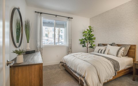a bedroom with a bed and a dresser and a window