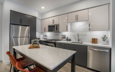 a kitchen with stainless steel appliances and a marble counter top