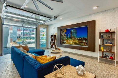 a living room with a blue couch and a large screen tv