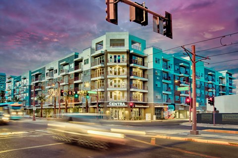 A street view of a city with a multi-story building with a sign that says "CENTRA" on it.