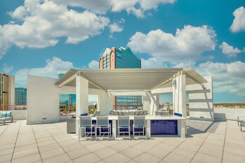 A white patio with a table and chairs under a white roof.