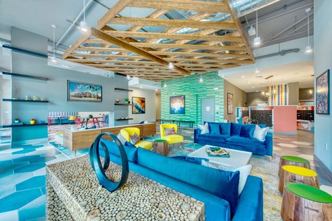 A modern living room with a blue sofa and a wooden ceiling.