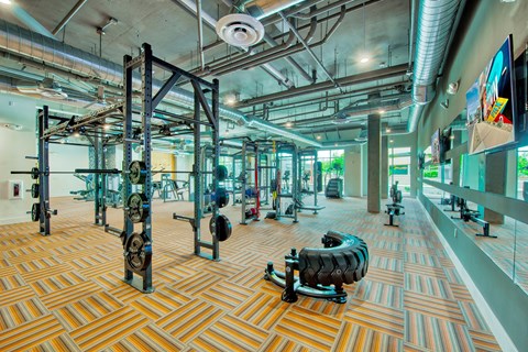 A gym with a variety of equipment including weight machines and free weights.