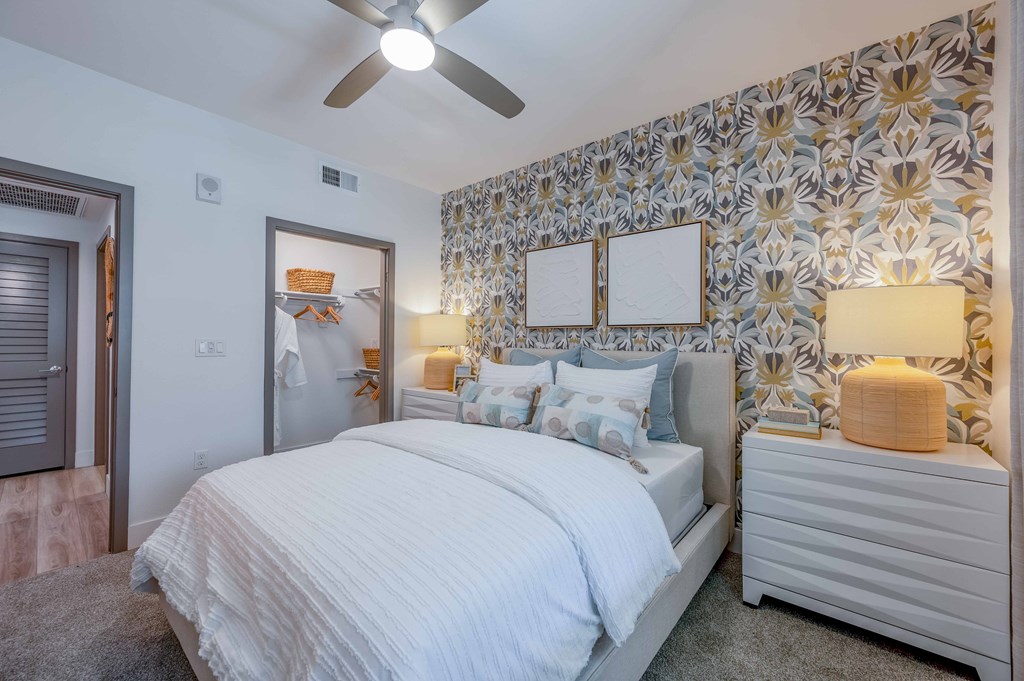 A bedroom with a large bed and a ceiling fan.