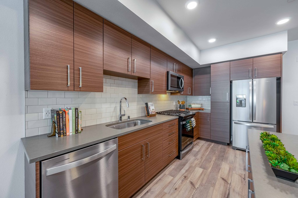 A modern kitchen with wooden cabinets and stainless steel appliances.