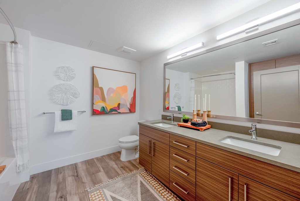 A bathroom with a wooden vanity and a white toilet.