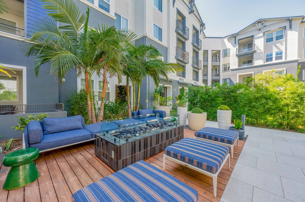 A patio with blue furniture around a fire pit
