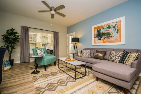 a living room with a couch and a chair and a ceiling fan