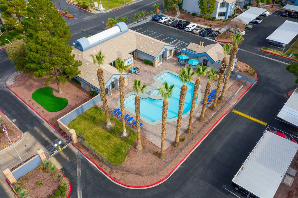 an aerial view of a pool and palm trees in a parking lot
