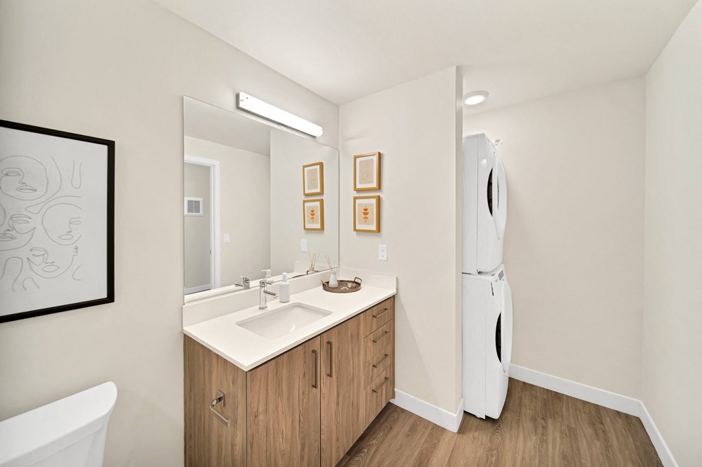 a bathroom with a sink and a mirror and washer/dryer