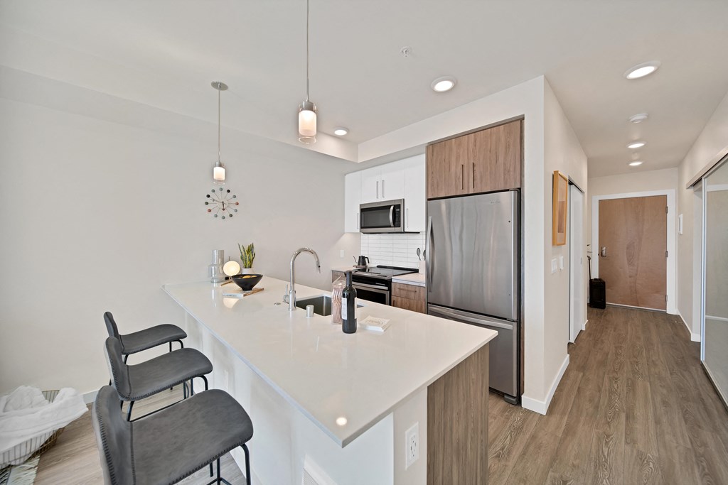 a kitchen with a large island and a stainless steel refrigerator