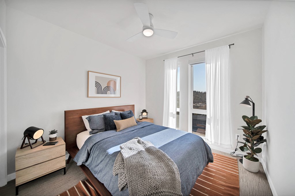 a bedroom with a bed and a large window