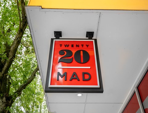 A sign with the number 20 and the word "MAD" on it.