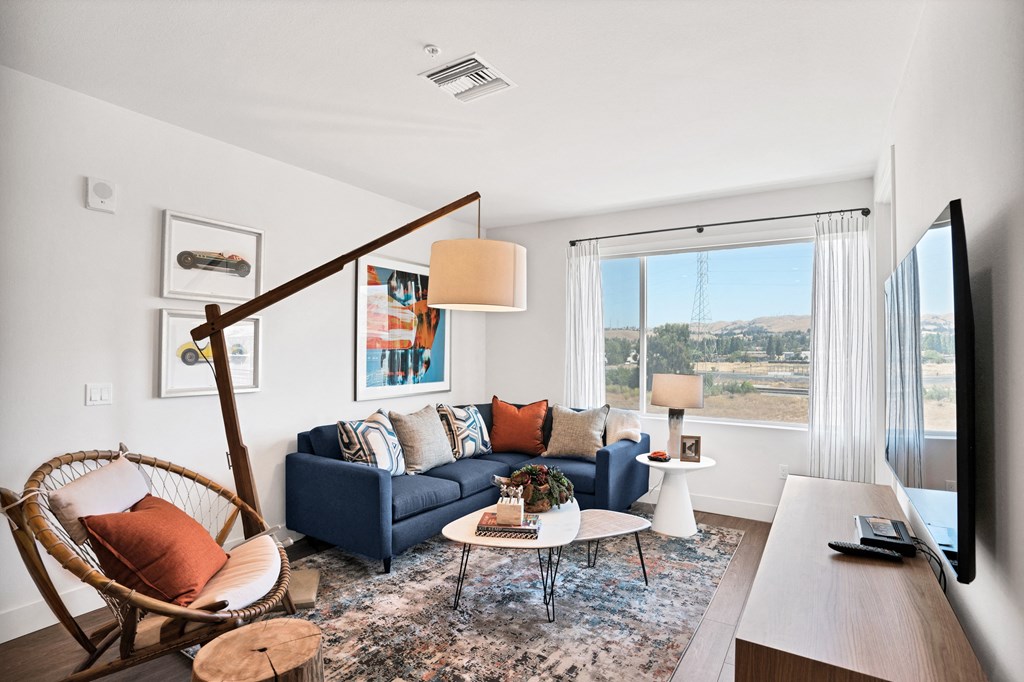 a living room with a blue couch and a large window