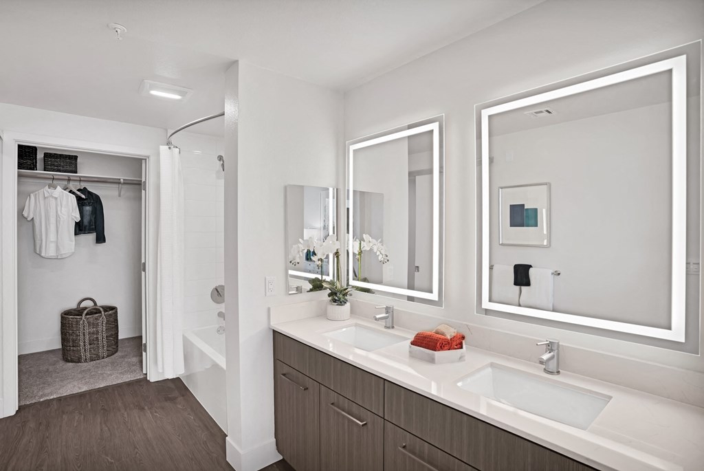 a bathroom with two sinks and two mirrors