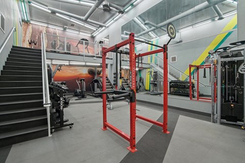 a view of the gym with weights machines and stairs