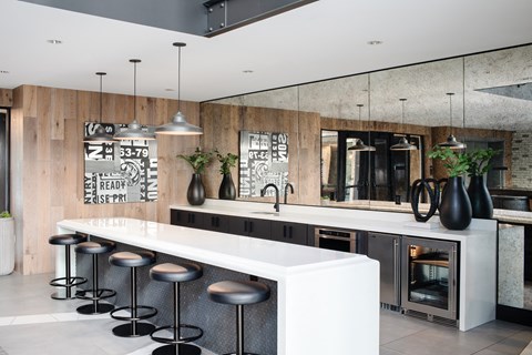 a large kitchen with a long white counter and bar stools