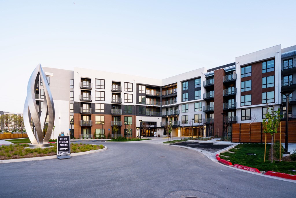 a street view of an apartment complex with a monument in the middle