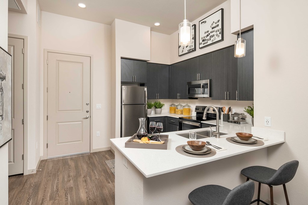 a kitchen with a large island and a stainless steel refrigerator