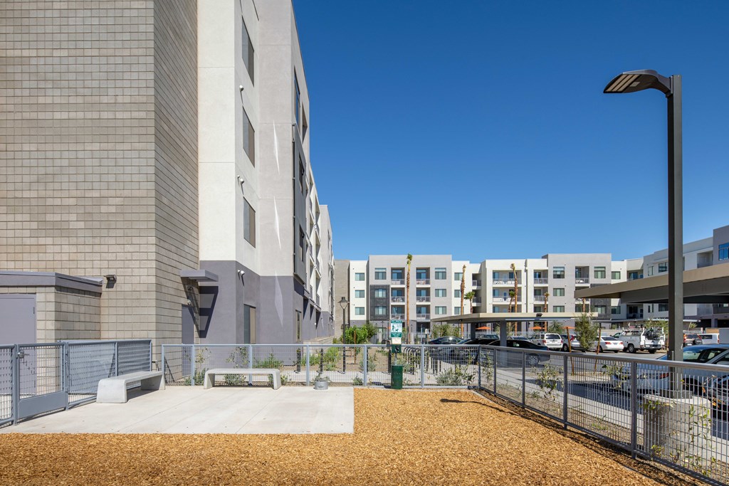 a large building with a sidewalk and a fence in front of it