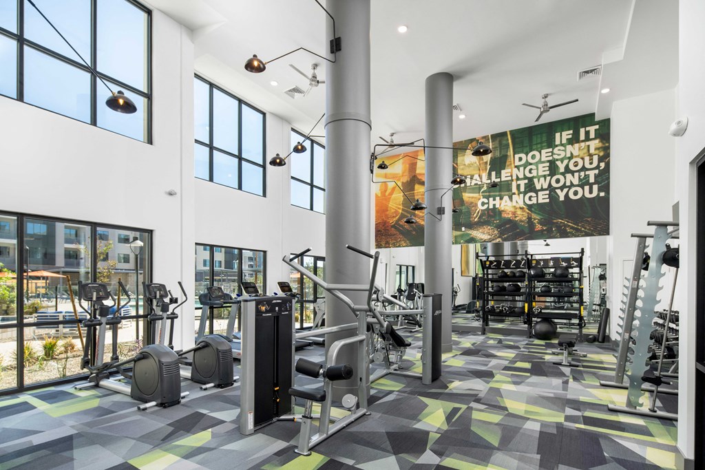 a gym with weights and cardio equipment and a large sign in the window