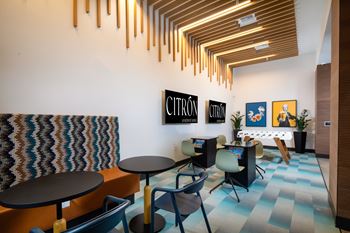An arcade room with a carpeted floor and a wooden ceiling with a light fixture.