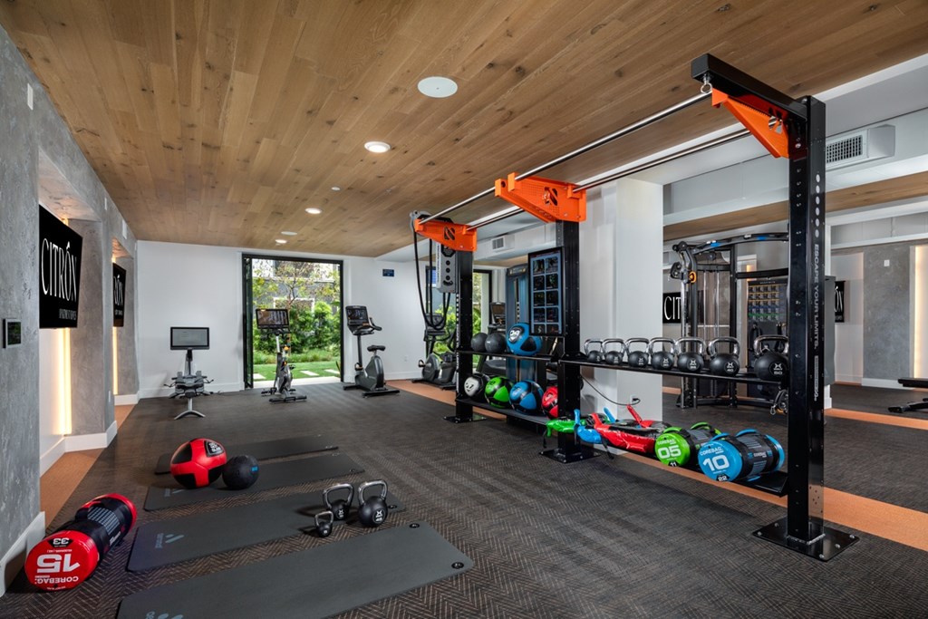 A gym with a variety of equipment including dumbbells, weight plates, and resistance bands.