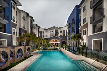 A swimming pool in the middle of a courtyard surrounded by buildings.