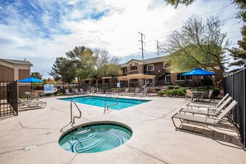 A swimming pool with a slide and lounge chairs.